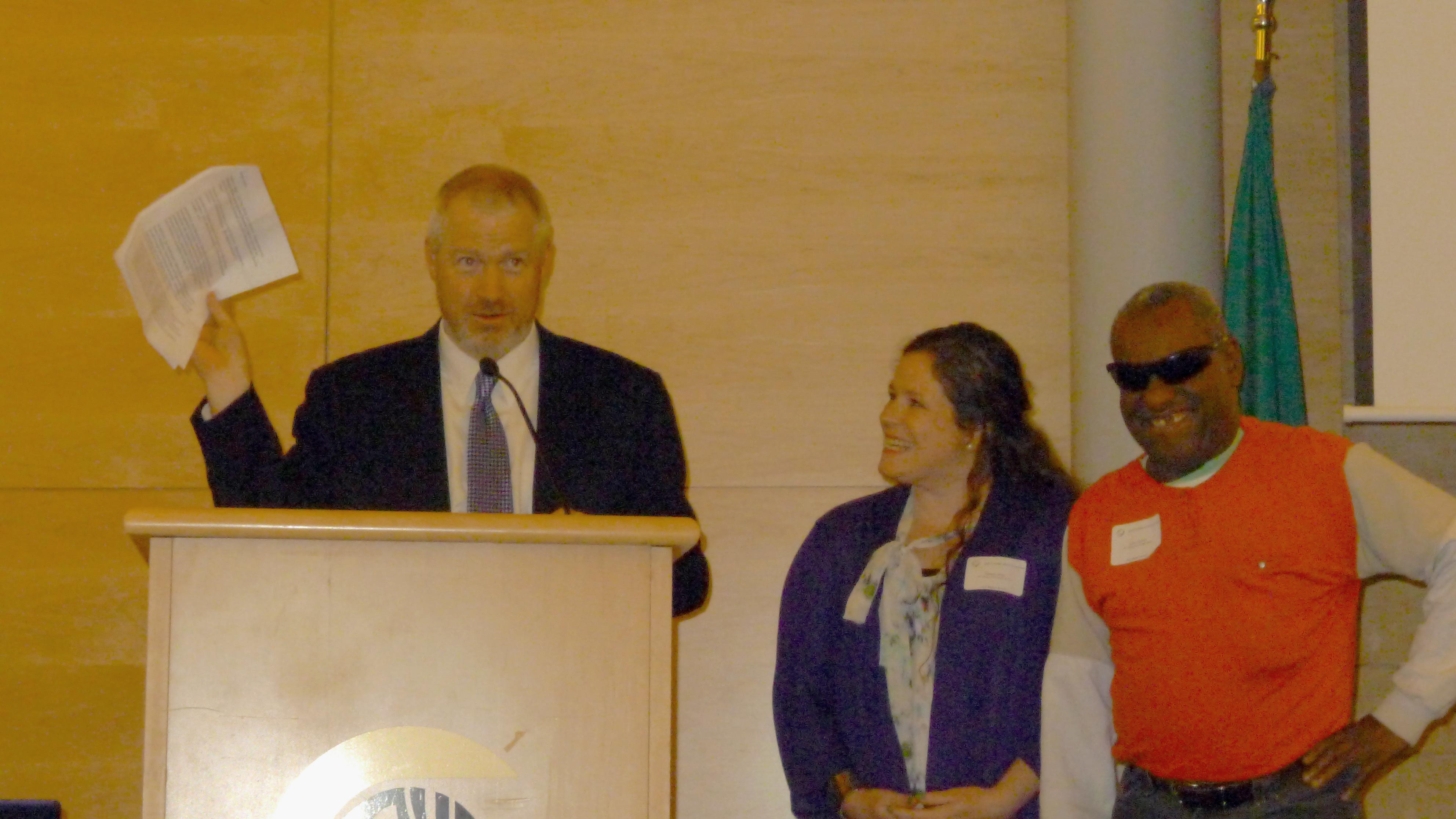 Image of Mayor Mike McGinn reading proclamation to Danielle Miller (WTBBL Program Manager), Quincy (WTBBL Patron). Image of Mayor Mike McGinn reading proclamation to Danielle and Quincy.