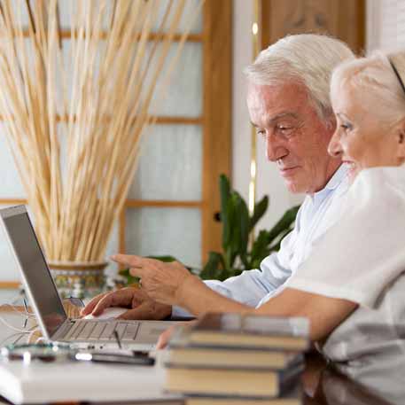 Two people performing research on a laptop