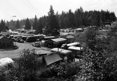 War-time workers lived in trailers, shacks, even chicken coops, as they poured into Bremerton in 1942. Note the barrage balloon on the horizon. The balloons were tethered to the ground by steel cables that could slice the wings off low-flying enemy aircraft. Puget Sound Navy Museum