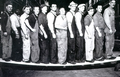 A black man poses with fellow shipyard workers during World War II. Puget Sound Navy Museum