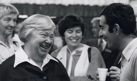 Governor Dixy Lee Ray talking to a smiling man at a Town Hall meeting.
