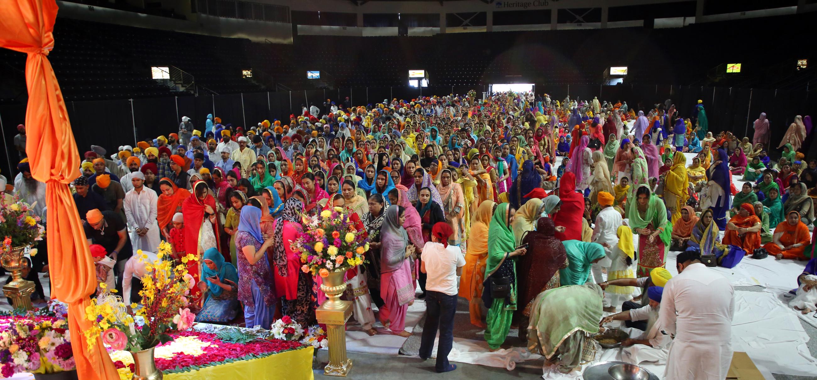 Sikh men and women line up to pay their respects to the Sikh holy book. 