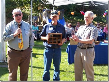 Mike Thompson receives award placque from Dan Speigle and applause from Sam Reed--grins all around