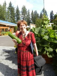 Carolyn Petersen holding a zucchini from the Hibulb Cultural Center