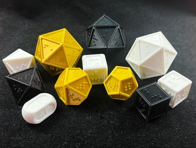 A full set of braille dice with 3 D20s.