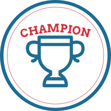 Red, white and blue circular logo. The word "CHAMPION" in red is curving above a simple blue outline of a trophy.